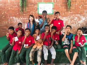 Photo-1: Children eating cookies and Mae Watanabe (wife of Daiki Watanabe) who is involved in the management of the academy