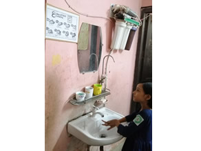 Photo-2: Hand-washing procedure Children washing their hands at school by looking at the poster